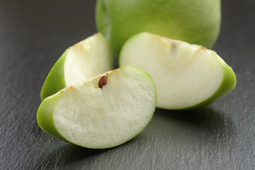 green sour apple on slate board sliced