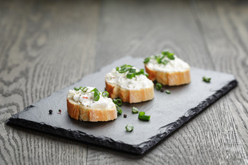 crunchy baguette slices with cream cheese and green onion on