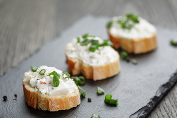 crunchy baguette slices with cream cheese and green onion on