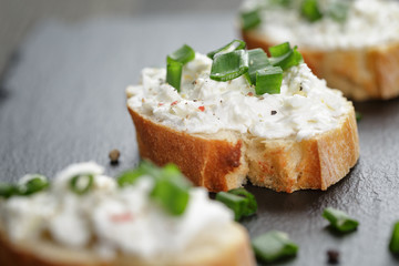 crunchy baguette slices with cream cheese and green onion on