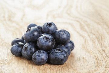 heap of fresh washed blueberries on wooden table