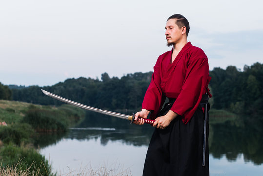 Man in ethnic samurai japanese clothing uniform with katana