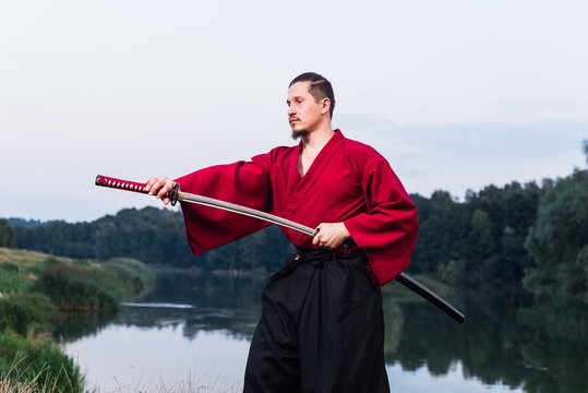Man in ethnic samurai japanese clothing uniform with katana