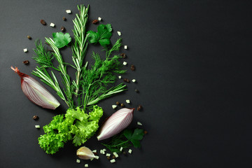 Black food background with fresh aromatic herbs and spices, view