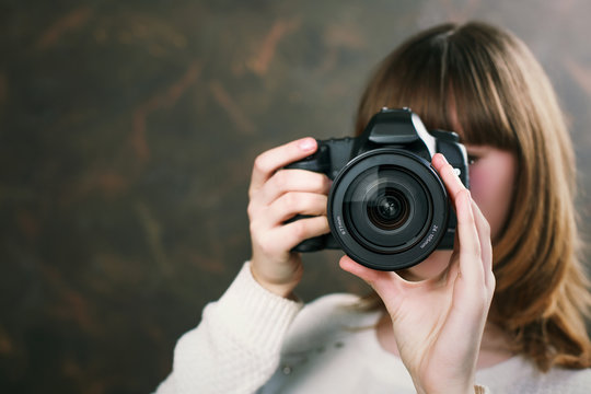 Young attractive woman smiling and holding a vintage camera