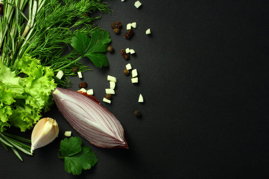 Black food background with fresh aromatic herbs and spices, view