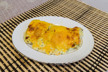 Cod fillets with cheese sauce on  plate