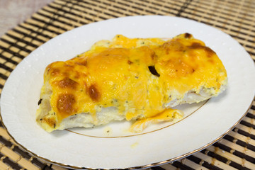 Cod fillets with cheese sauce on  plate