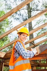 Female Worker Cutting Wood With Handsaw At Site