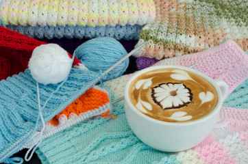 Obraz na płótnie Canvas A cup of latte art on a knitted vest background