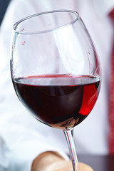 man handing glass of wine