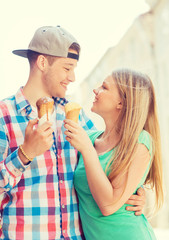 smiling couple with ice-cream in city