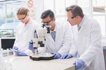 Scientists examining something with the microscope
