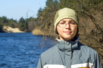 The boy stands on the banks of the river Stugna and smiling