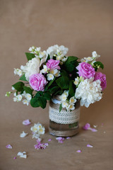 Bouquet of jasmine, peonies and tea roses in a decorative glass 