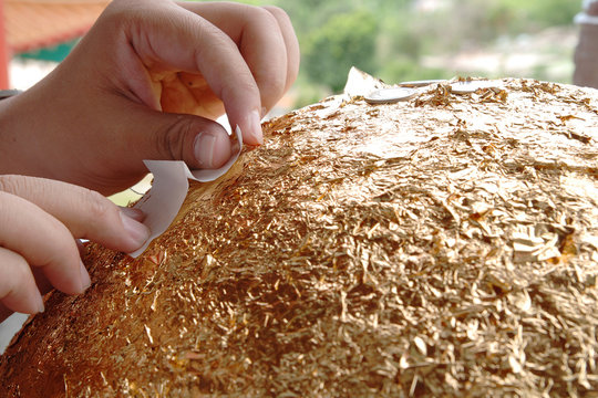 Hand paste holy gold paper at temple