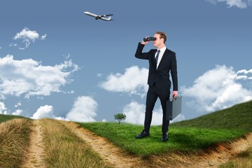 Composite image of businessman looking through binoculars