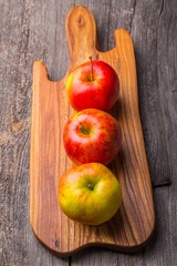 Fresh apples on wooden cutting board