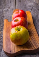 Fresh apples on wooden cutting board