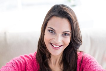 Smiling beautiful brunette relaxing on the couch
