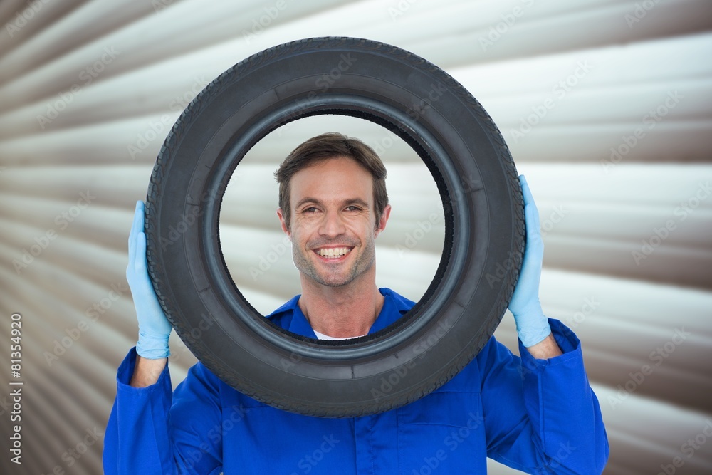 Poster composite image of confident mechanic looking through tire