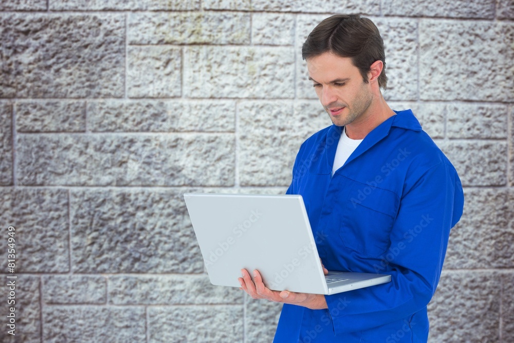 Poster Composite image of mechanic using laptop over white background