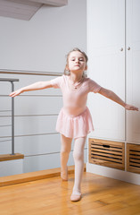 Little girl practicing ballet in a dance studio