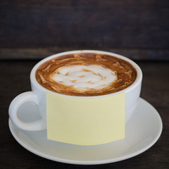 A cup of coffee with latte art and on wooden background