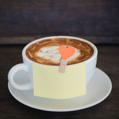 A cup of coffee with latte art and on wooden background