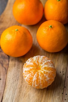 fresh tangerines on wooden cutting board
