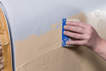 Spachtelarbeiten an einem Oldtimer Auto