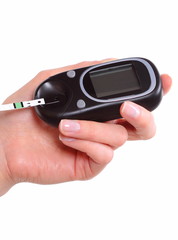 Closeup of strip for glucose testing and glucose meter