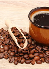 Heap of coffee grains and cup of beverage