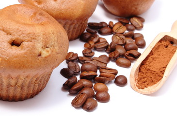 Fresh baked muffins, coffee grains and powdery cinnamon