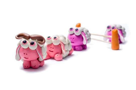 Little plasticine sheep jumping over a fence.