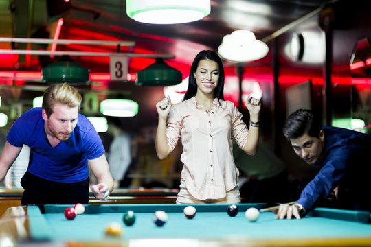Young people playing snooker in a club / pub / bar