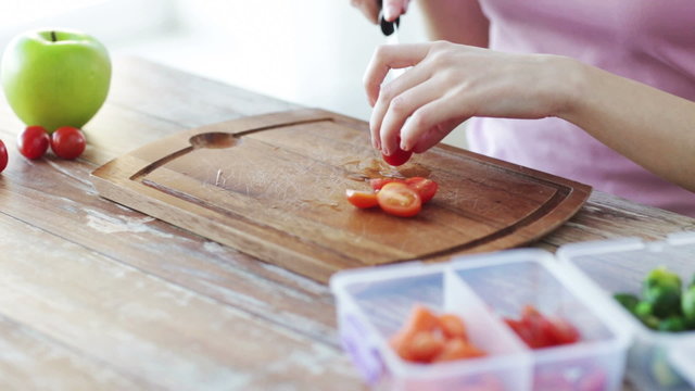 close up of woman chopping vegetables at home