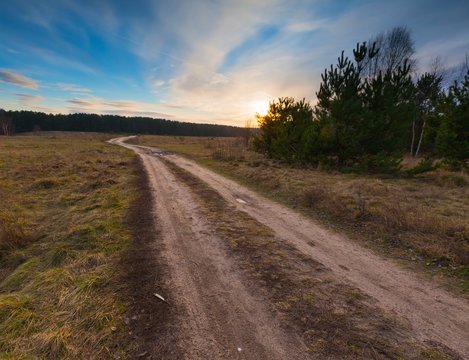 Sandy Rural Road And Sunset On Field.