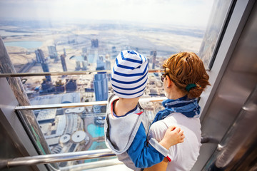 Young woman and son looking out of window from Burj Khalifa