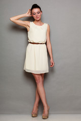 Fototapeta premium Glamour girl in white dress on gray