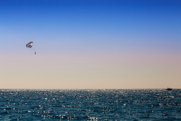 parasailing man over blue sea
