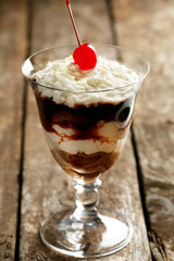 Tasty tiramisu dessert in glass, on wooden background
