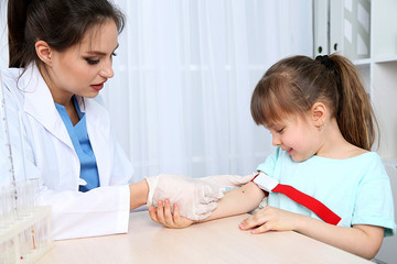 Nurse with syringe is taking blood for test in hospital