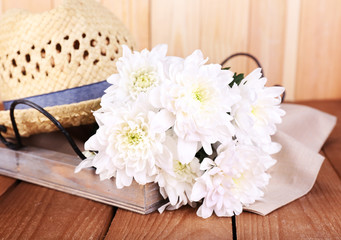 Fototapeta na wymiar Hat with flowers on wooden background
