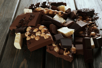 Set of chocolate with hazelnut on wooden table, closeup