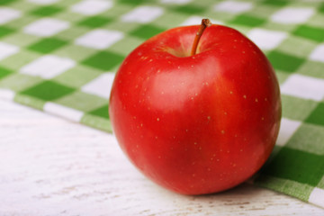 Apple with napkin on wooden table, closeup