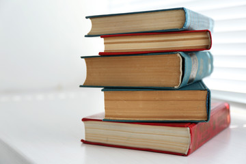 Books on white windowsill, close up
