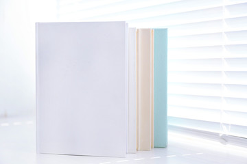 Naklejka premium Books on white windowsill, close up