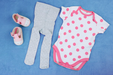Clothes for baby girl on colorful background