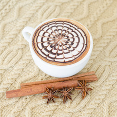 A cup of latte art on a knitted  background